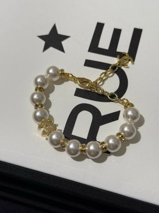 Chanel light gold bracelet with white pearls and full pavé-set stones.